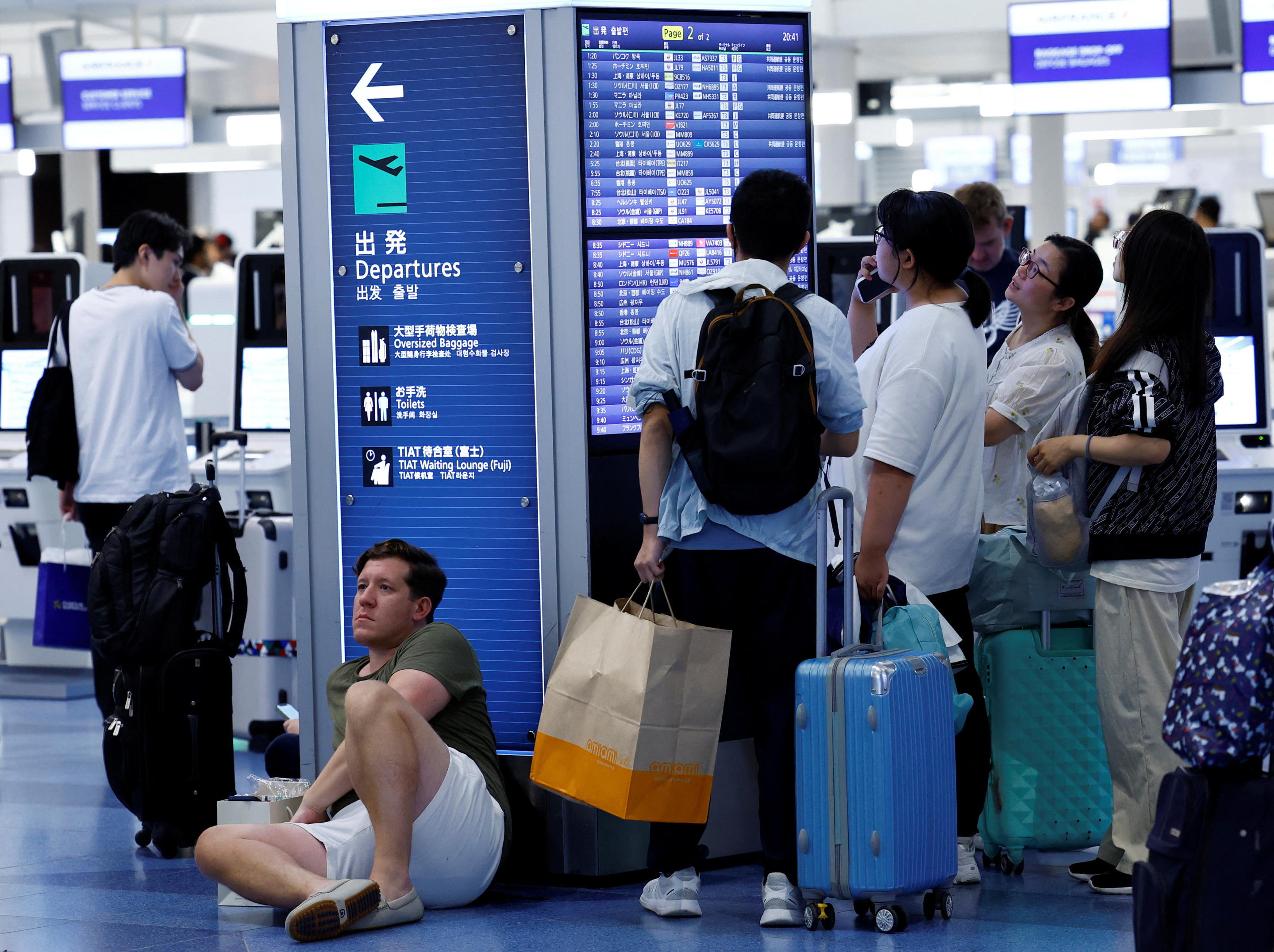 Passengers check flight information at Haneda Airport in Tokyo.