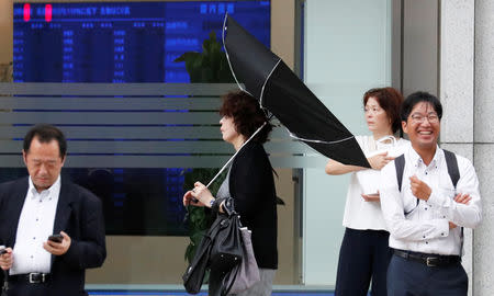 A woman using an umbrella struggles against strong wind and rain caused by Typhoon Jebi, in Tokyo, Japan, September 4, 2018. REUTERS/Toru Hanai