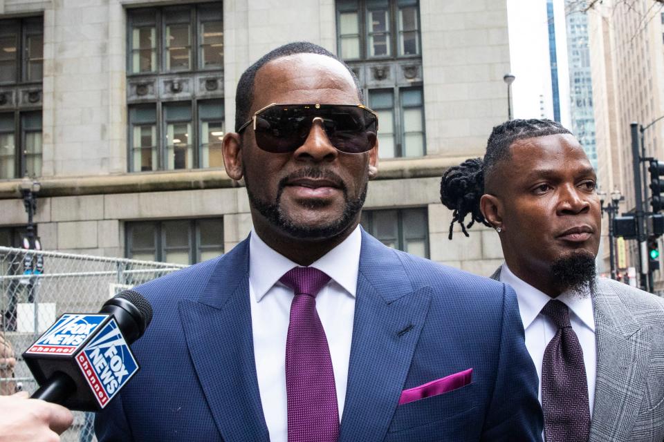 FILE - This March 13, 2019 file photo shows R. Kelly and his publicist Darryll Johnson, right, leaving The Daley Center after an appearance in court for Kelly's child support case in Chicago. Prosecutors in Chicago have charged Kelly with 11 new sex assault charges, some that are more serious than those first filed against him in February. The Chicago Sun-Times reported Thursday, May 30, on its website that the charges include counts that carry a potential sentence of up to 30 years in prison. The charges say the alleged offenses happened in 2010. (Ashlee Rezin/Chicago Sun-Times via AP, File) ORG XMIT: ILCHS306