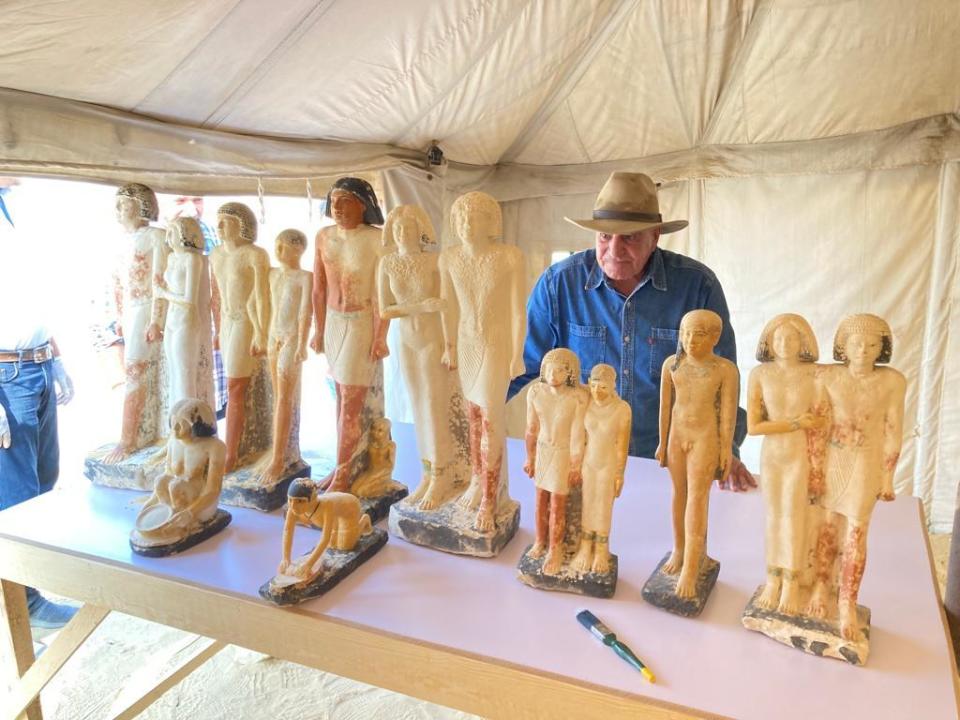 Dr. Zahi Hawass, a veteran Egyptian archaeologist, admires stone statues found by his team in a vertical shaft some 33 feet deep at the Gisr el-Mudir dig site in Saqqara, outside Cairo, Egypt, which date back to the 