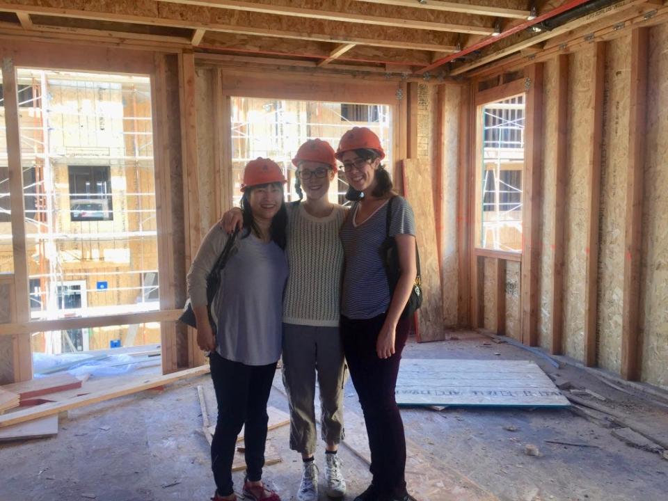 May Leong with two others wearing hard hats at her unfinished Oakland home.