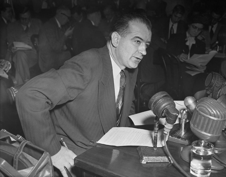 FILE - Sen. Joseph McCarthy, R-Wis., accuses Haldore Hanson, key State Department official, of "pro-Communist" activities dating back to 1938, during a Senate foreign relations subcommittee, March 13, 1950. From the Salem witch trials to fears of the Illuminati to the Red Scare to QAnon, conspiracy theories have always served as dark counter programming to the American story taught in history books. (AP Photo/Herbert K. White, File)