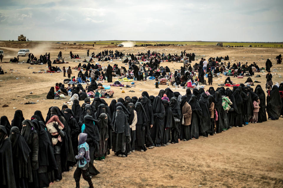 Women and children queue at a screening point as hundreds of civilians, who streamed out of the Islamic State group's last Syrian stronghold, arrive in an area run by U.S.-backed Syrian Democratic Forces outside Baghouz in the eastern Syrian Deir Ezzor province on March 5, 2019. (Delil Souleiman / AFP via Getty Images file)