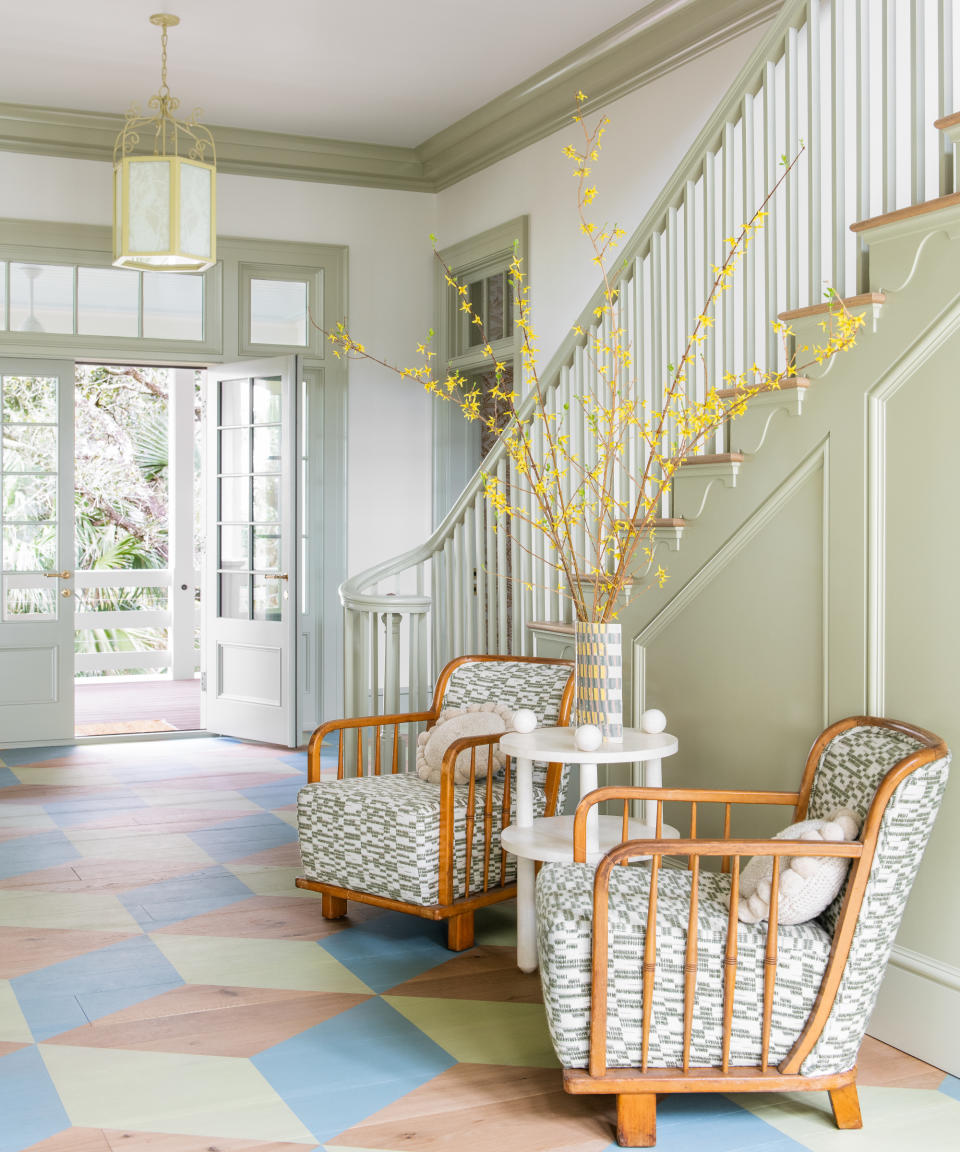 hall  with wooden floor with colorful geometric design,  mid century style chairs with green pattern and green woodwork