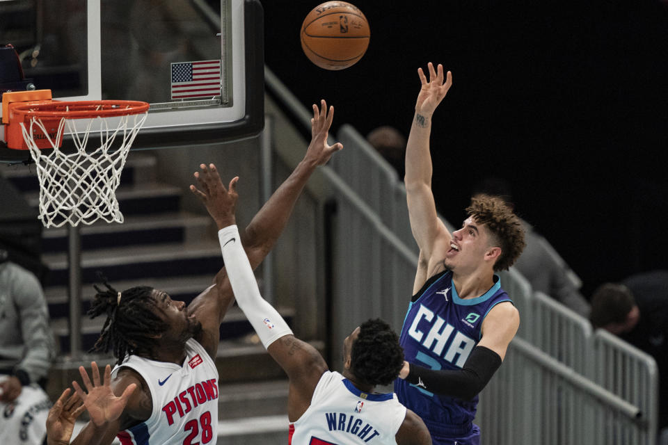 Charlotte Hornets guard LaMelo Ball, right, shoots the ball over Detroit Pistons center Isaiah Stewart, left, and guard Delon Wright during the first half of an NBA basketball game in Charlotte, N.C., Thursday, March 11, 2021. (AP Photo/Jacob Kupferman)
