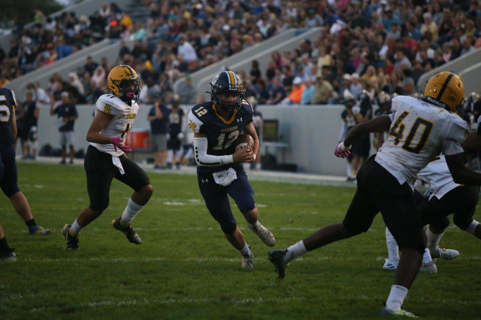 Port Huron Northern quarterback Dylan Bloink runs for a touchdown during the Huskies' 43-8 win over Sterling Heights at Memorial Stadium in Port Huron on Friday.