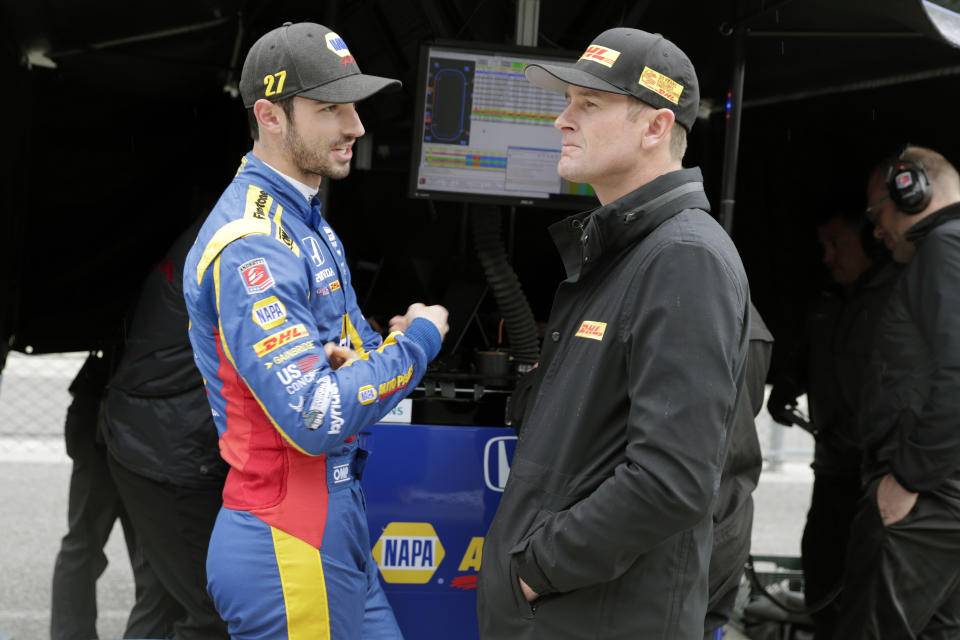 IndyCar drivers Alexander Rossi, left, and Ryan Hunter-Reay talks during a rain delay during auto racing testing at the Indianapolis Motor Speedway in Indianapolis, Wednesday, April 24, 2019. (AP Photo/Michael Conroy)