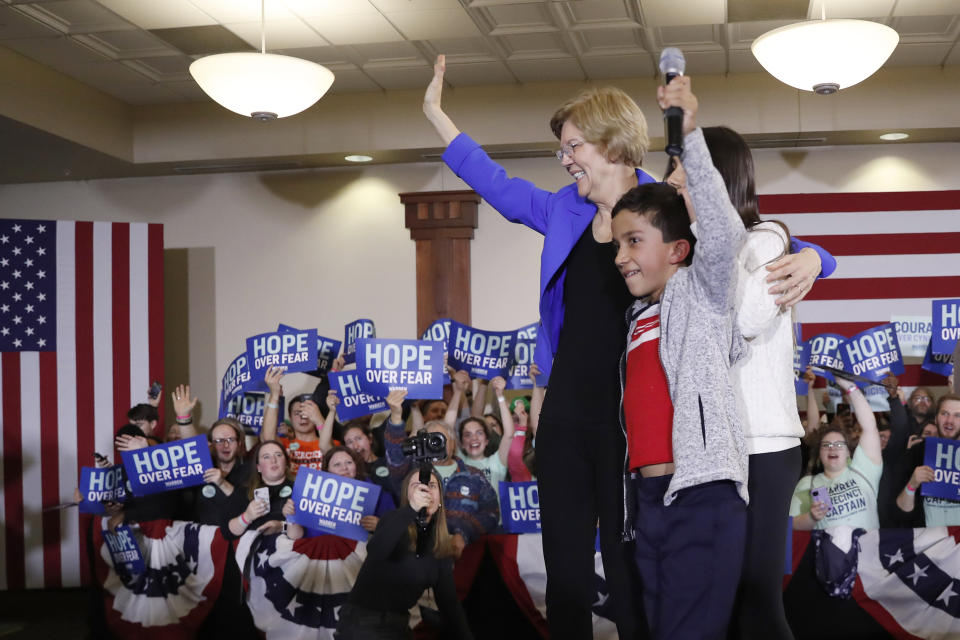 Democratic presidential candidate Sen. Elizabeth Warren, D-Mass., stands on stage with her grandchildren, Atticus Mann Tyagi, center, and Lavinia Tyagi, as she arrives to speak at a caucus night rally the Forte Banquet and Conference Center, Monday, Feb. 3, 2020, in Des Moines, Iowa. (AP Photo/Andrew Harnik)