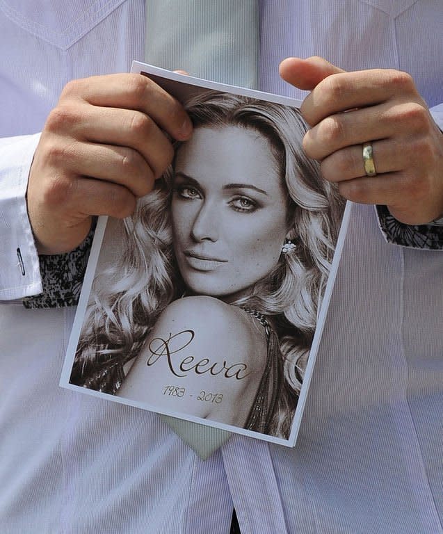 A relative of the late South African model Reeva Steenkamp holds the funeral program at the crematorium building in Port Elizabeth, South Africa on February 19, 2013. With the South African sporting hero already facing a tough fight to win bail, the prosecution presented police evidence to flesh out the charge he deliberately murdered the cover girl on Valentine's Day