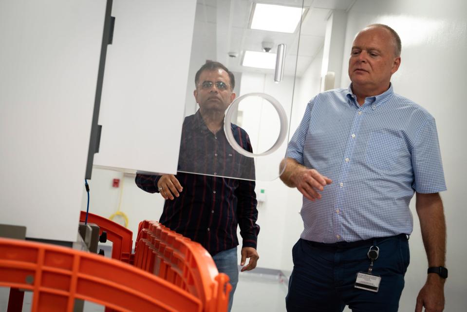 Chirag Vyas, project manager and scientist, left, and Thomas Glasmacher, FRIB laboratory director, look at a machine for isotope harvesting inside the Facility for Rare Isotope Beams (FRIB) at Michigan State University in East Lansing on Tuesday, Aug. 1, 2023. In the radiochemistry lab, isotopes from beam dump water are collected and produce purified radioisotopes for different applications such as nuclear astrophysics to nuclear medicine.