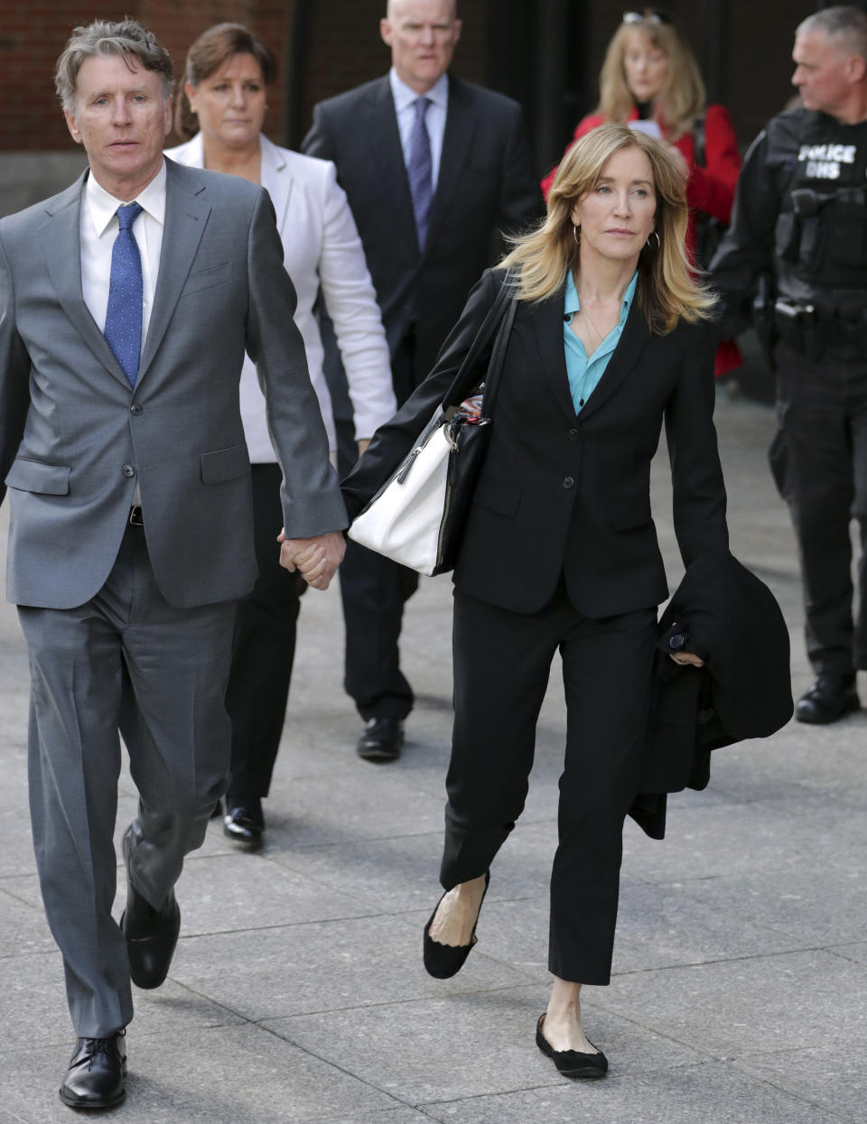 Actress Lori Loughlin, front, and husband, clothing designer Mossimo Giannulli, left, depart federal court in Boston on Wednesday, April 3, 2019, after facing charges in a nationwide college admissions bribery scandal. (AP Photo/Steven Senne)