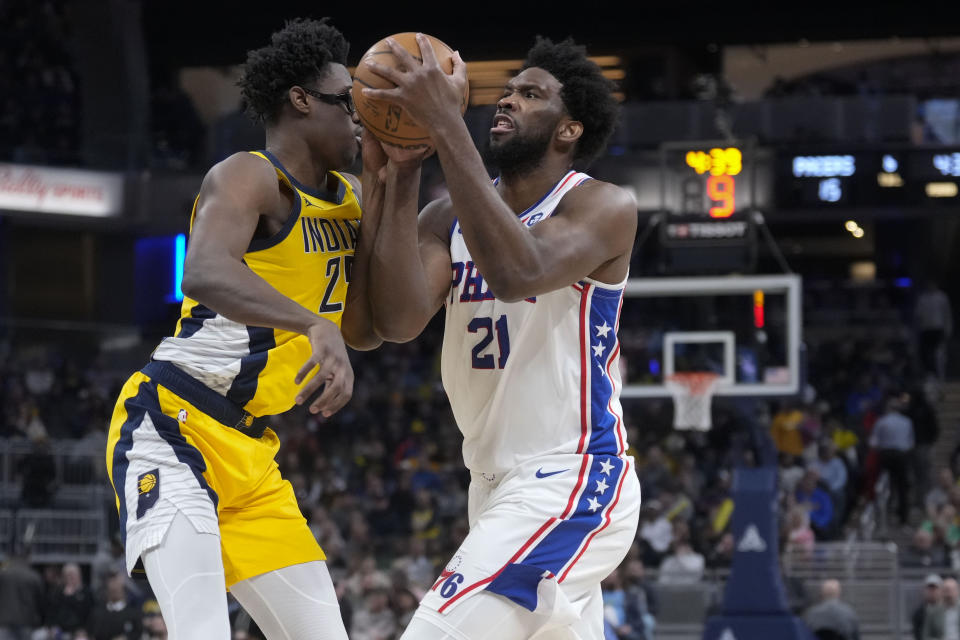 Philadelphia 76ers center Joel Embiid, right, moves against Indiana Pacers forward Serge Ibaka during the first half of an NBA basketball game in Indianapolis, Saturday, March 18, 2023. (AP Photo/AJ Mast)