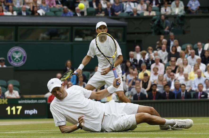 Bob Bryan, front, slips on the grass during the Wimbledon men's doubles final. (AP Photo/Sang Tan)