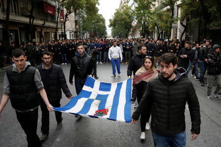 Athens' Polytechnic school students carry a blood-stained Greek flag during a rally marking the 45th anniversary of a 1973 student uprising against the military dictatorship that was ruling Greece, in Athens, Greece, November 17, 2018. REUTERS/Costas Baltas