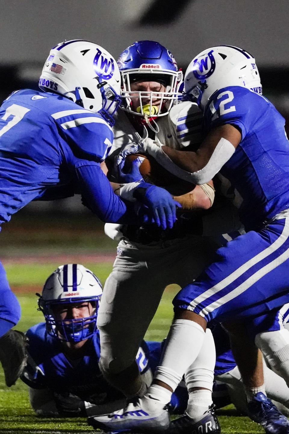 Wyoming defensive back Matty Mitchell (7) and Wyoming linebacker D.J. Gray (12) tackle Clinton-Massie running back Logan Chesser (6) during the first half of an OHSAA Division IV high school football regional semifinal at Lakota West High School, Saturday, Nov. 12, 2022.