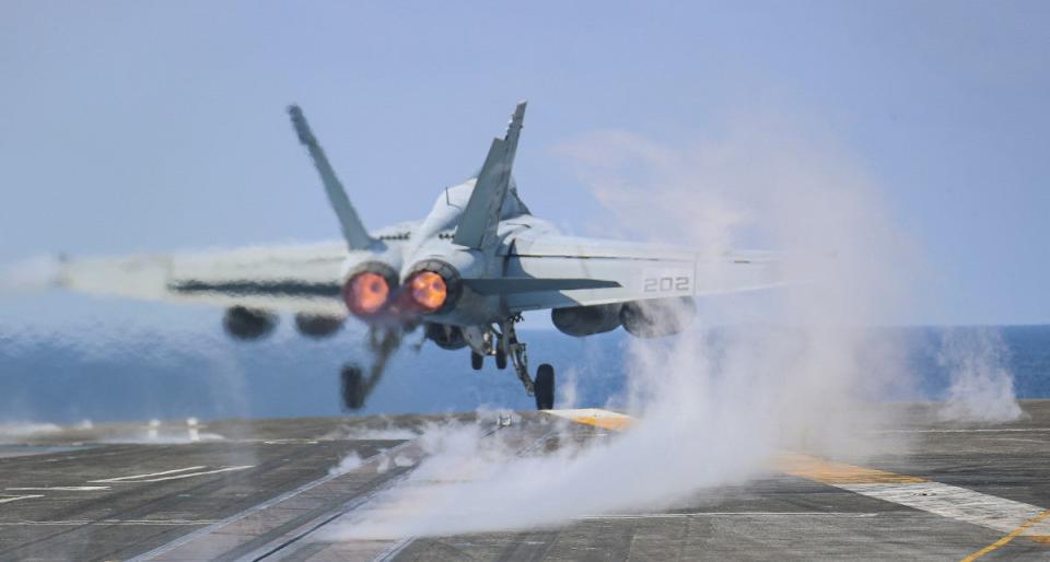 Steam is seen rising from one of the catapult tracks on the U.S. Navy's <em>Nimitz</em> class aircraft carrier USS <em>Abraham Lincoln</em> as an EA-18G Growler electronic warfare jet is launched. <em>USN</em>