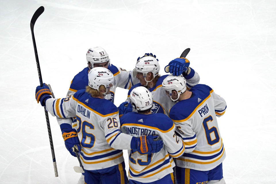 Buffalo Sabres players celebrate with Vinnie Hinostroza (29) after he scored during the first period of an NHL hockey game against the Boston Bruins, Saturday, Jan. 1, 2022, in Boston. (AP Photo/Mary Schwalm)