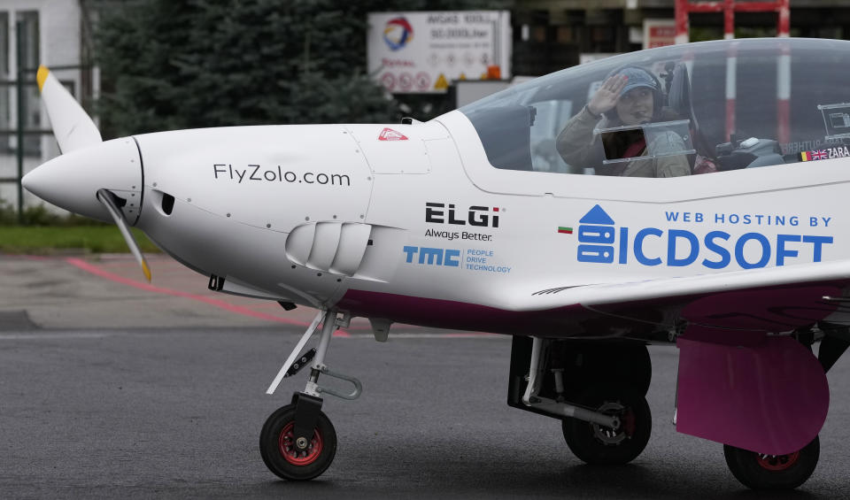 FILE - Belgian-British teenager Zara Rutherford waves from under the canopy of her Shark ultralight plane prior to take off at the Kortrijk-Wevelgem airfield in Wevelgem, Belgium, Aug. 18, 2021. Rutherford is set to land in Kortrijk, Belgium on Monday, Jan. 17, 2022, in the hopes of completing her trek around the world as the youngest woman ever, beating the mark of American aviator Shaesta Waiz, who was 30 when she set the previous benchmark. (AP Photo/Virginia Mayo, File)