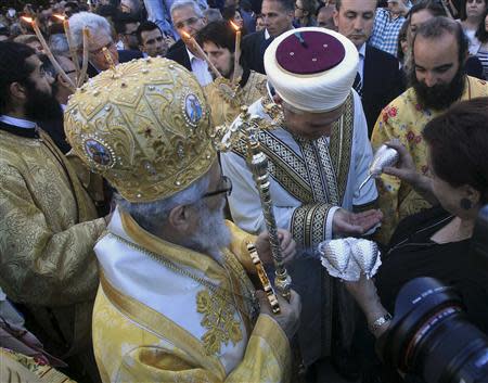 A Greek Orthodox bishop and an Islamic cleric attend a Good Friday liturgy at the Church of St. George Exorinos in Famagusta, northern Cyprus, April 18, 2014. REUTERS/Andreas Manolis