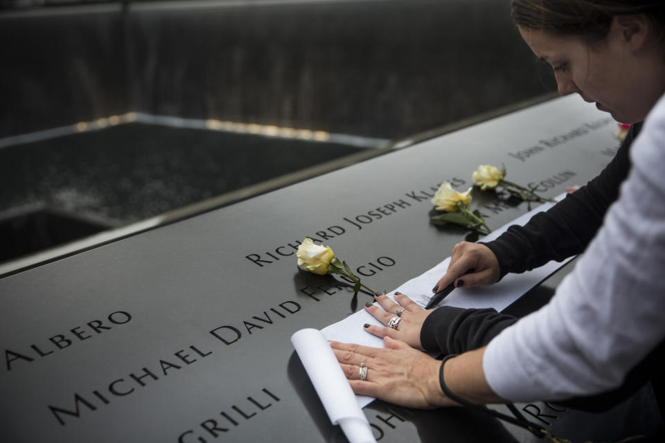 NEW YORK, NY - SEPTEMBER 11: Family members etch their loved one's names in paper prior to the memorial observances held at the site of the World Trade Center on September 11, 2014 in New York City. This year marks the 13th anniversary of the September 11th terrorist attacks that killed nearly 3,000 people at the World Trade Center, Pentagon and on Flight 93. (Photo by Andrew Burton/Getty Images)