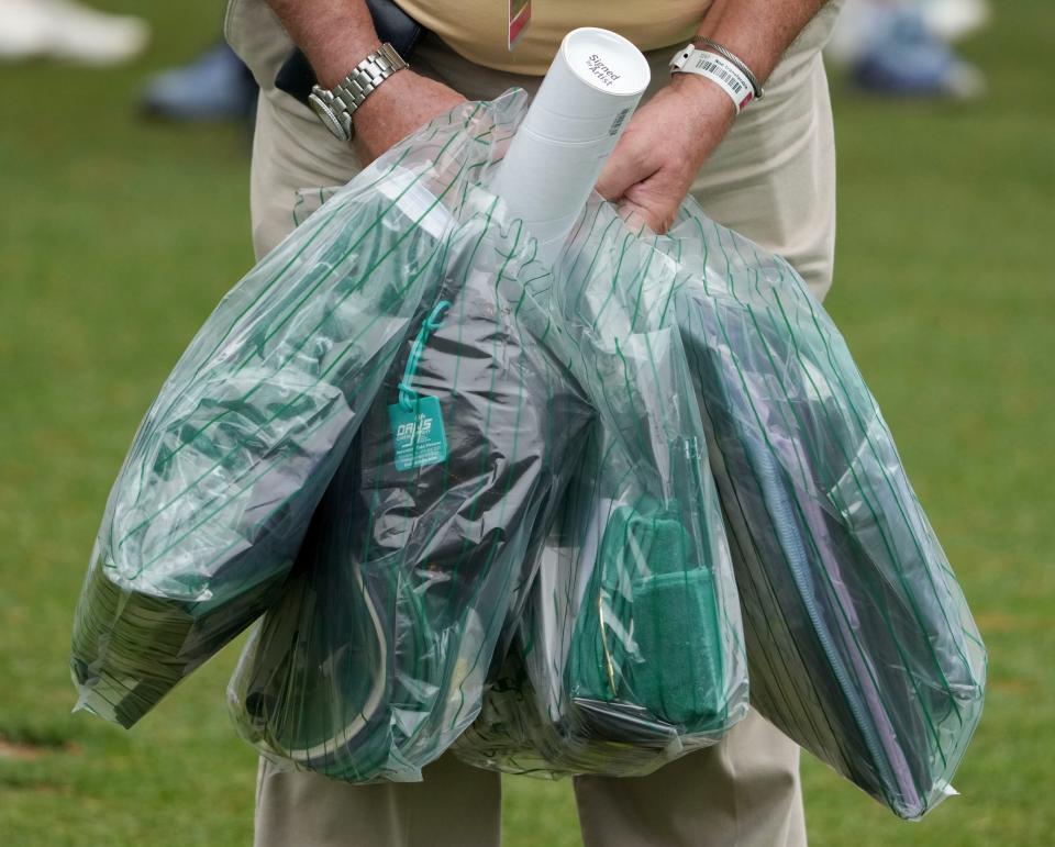 Apr 4, 2023; Augusta, Georgia, USA; A patron carries bags of merchandise from the golf shop on no. 14 during a practice round for The Masters golf tournament at Augusta National Golf Club. Mandatory Credit: Kyle Terada-USA TODAY Network