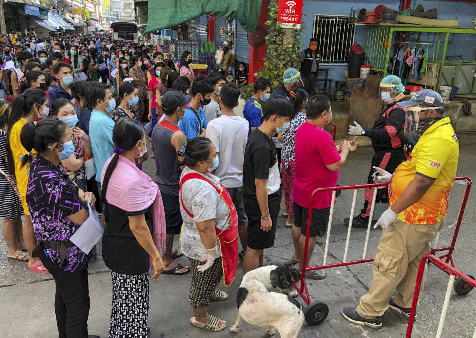 People stand in lines to get COVID-19 tests in Samut Sakhon, South of Bangkok, Thailand, Sunday, Dec. 20, 2020. Thailand reported more than 500 new coronavirus cases on Saturday, the highest daily tally in a country that had largely brought the pandemic under control. (AP Photo/Jerry Harmer)