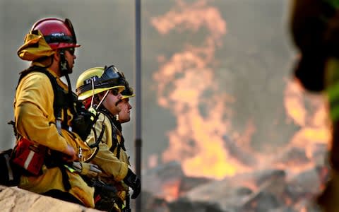 Firefighters tackle a blaze in Malibu - Credit: Getty