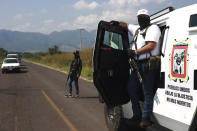 Members of the so-called self-defense group known as United Towns or Pueblos Unidos, gather for a rally in Nuevo Urecho, in the Mexican western state of Michoacan, Saturday Nov. 27, 2021. Extortion of avocado growers in western Mexico has gotten so bad that 500 vigilantes from the "self-defense" group gathered Saturday and pledged to aid police. (AP Photo/Armando Solis)