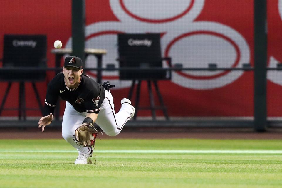 Arizona Diamondbacks center fielder Daulton Varsho (12) narrowly misses a catch against the Washington Nationals at Chase Field on Saturday, July 23, 2022, in Phoenix. The Arizona Diamondbacks won the game 7 to 2.