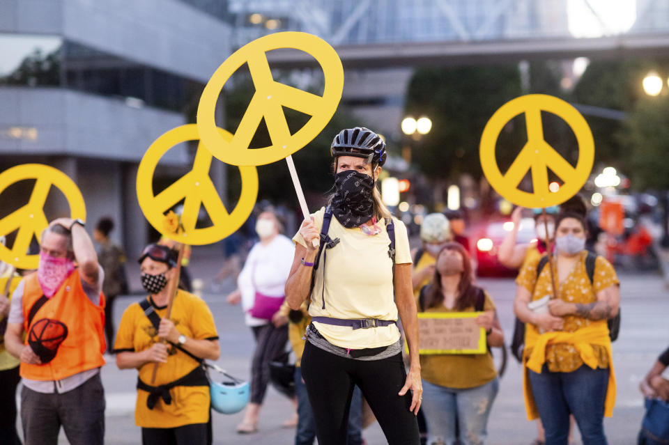 Mary Hubert, part of a "wall of moms," holds a peace sign during a Black Lives Matter rally on Wednesday, July 22, 2020, in Portland, Ore. (AP Photo/Noah Berger)