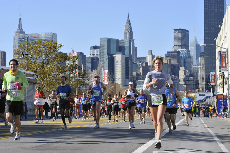 ARCHIVO - En esta foto del 6 de noviembre de 2011, los corredores pasan por una avenida del condado de Queens durante el maratón de Nueva York.(AP Foto/Kathy Kmonicek, Archivo)