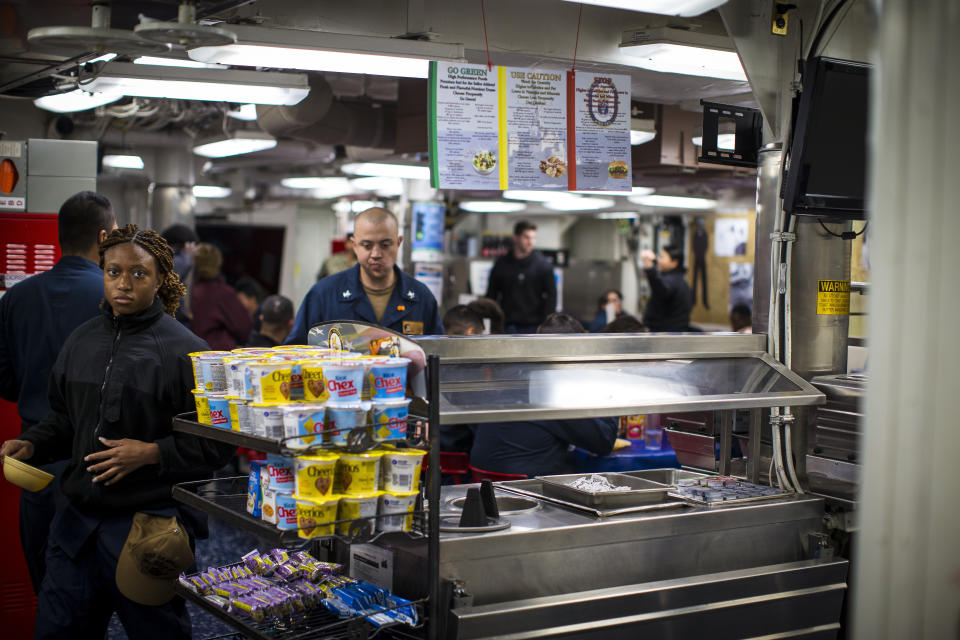 Sailors aboard the Arleigh Burke-class destroyer USS Gravely (DDG-107) navigate through the ship's mess deck on Tuesday, March 14, 2023 while home ported at Norfolk Naval Station in Norfolk, Va. The U.S. Navy is planning to make chaplains regular members of the crew on ships with more than 300 sailors, instead of only the largest carriers as in the past. (AP Photo/John C. Clark)