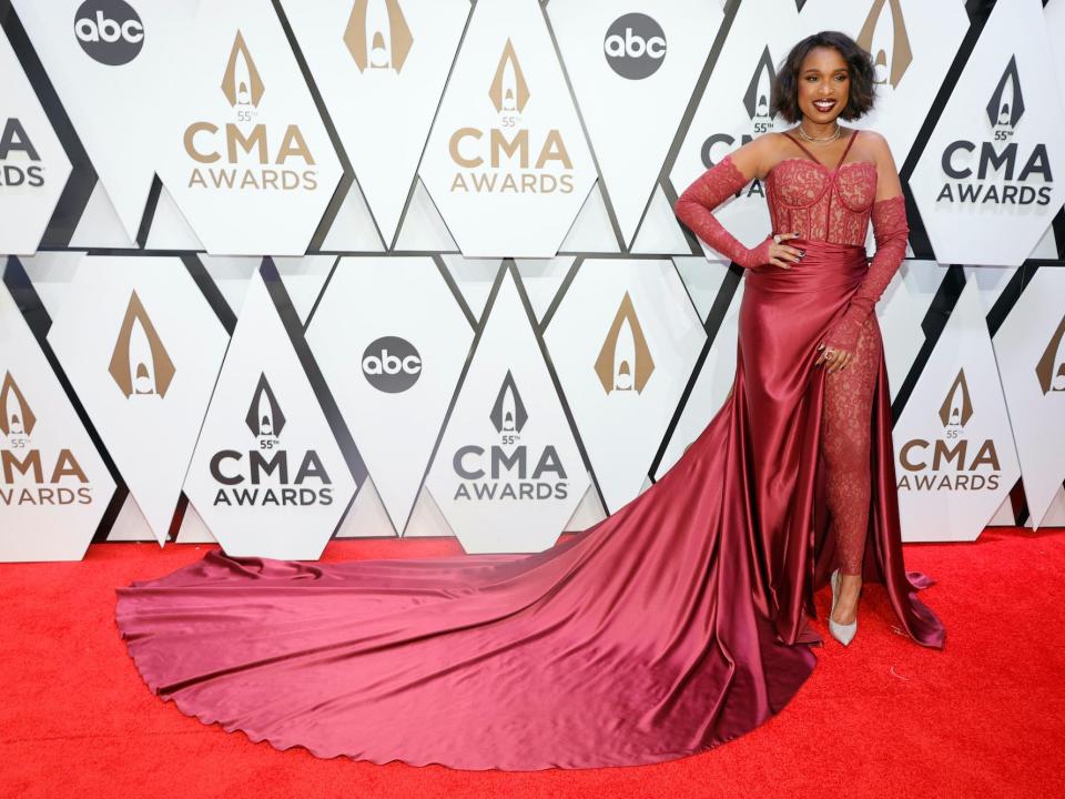 Jennifer Hudson wears a red dress with a long train at the CMA Awards.