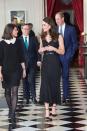 <p>In a black tweed gown with a thin leather belt, ankle strap pumps and pearl jewelry at the British Embassy in Paris.</p>