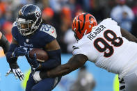 Tennessee Titans running back Derrick Henry (22) runs near Cincinnati Bengals nose tackle D.J. Reader (98) during the first half of an NFL divisional round playoff football game, Saturday, Jan. 22, 2022, in Nashville, Tenn. (AP Photo/John Amis)