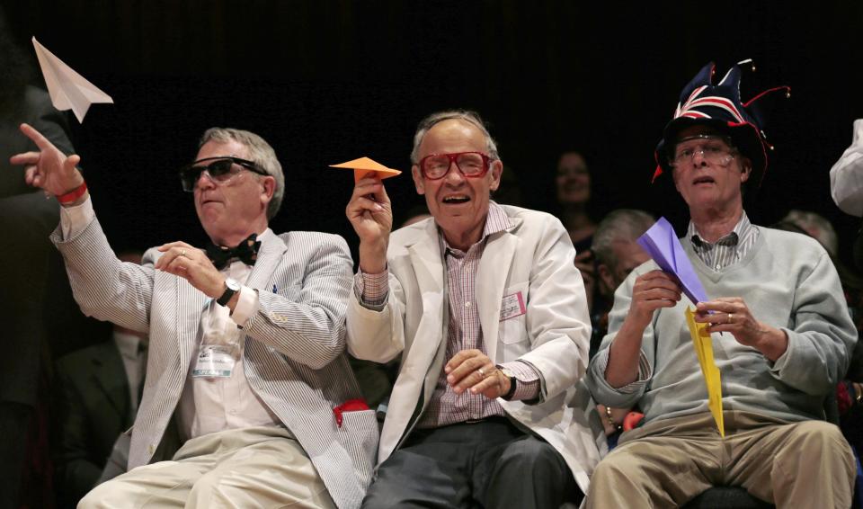 CORRECTS TO REFLECT THAT KIRSHNER IS NOT A NOBEL LAUREATE, ADDS HIS CURRENT TITLE - Harvard University Clowes Professor of Science Robert Kirshner, left, along with Nobel laureates Dudley Herschbach, center, and Rich Roberts, fire paper airplanes back at the audience during a performance at the Ig Nobel Prize ceremony at Harvard University, in Cambridge, Mass., Thursday, Sept. 20, 2012. The Ig Nobel prize is an award handed out by the Annals of Improbable Research magazine for silly sounding scientific discoveries that often have surprisingly practical applications.(AP Photo/Charles Krupa)