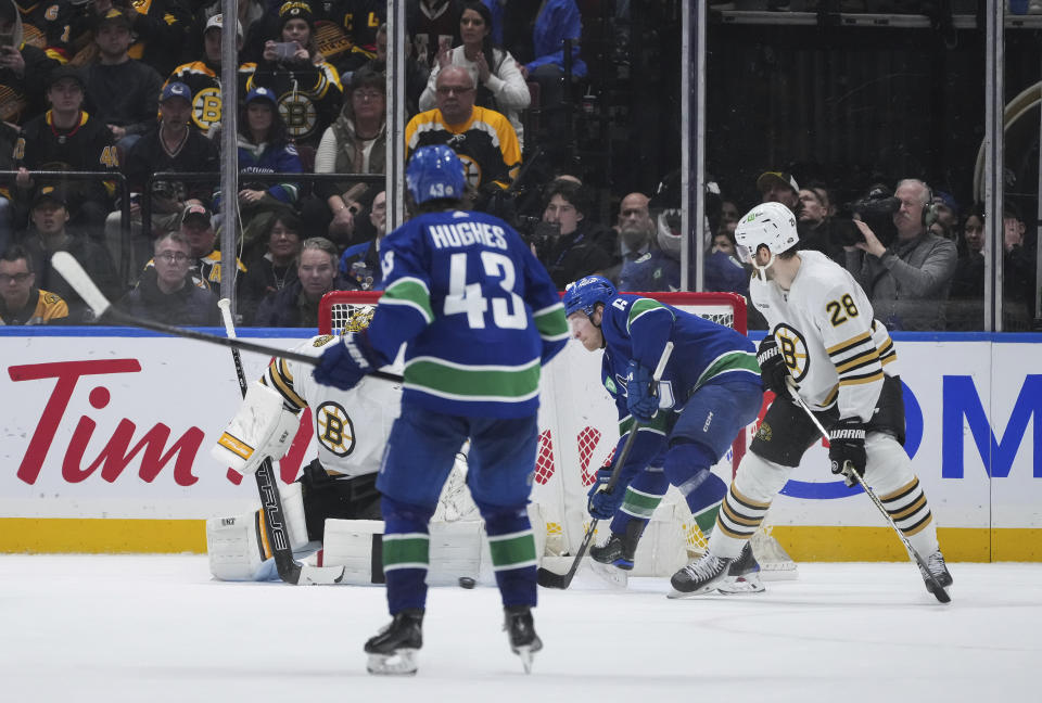 Vancouver Canucks' Brock Boeser, second from right, scores the winning goal against Boston Bruins goalie Jeremy Swayman, left, as Bruins' Derek Forbort (28) watches during overtime NHL hockey game action in Vancouver, British Columbia, Saturday, Feb. 24, 2024. (Darryl Dyck/The Canadian Press via AP)