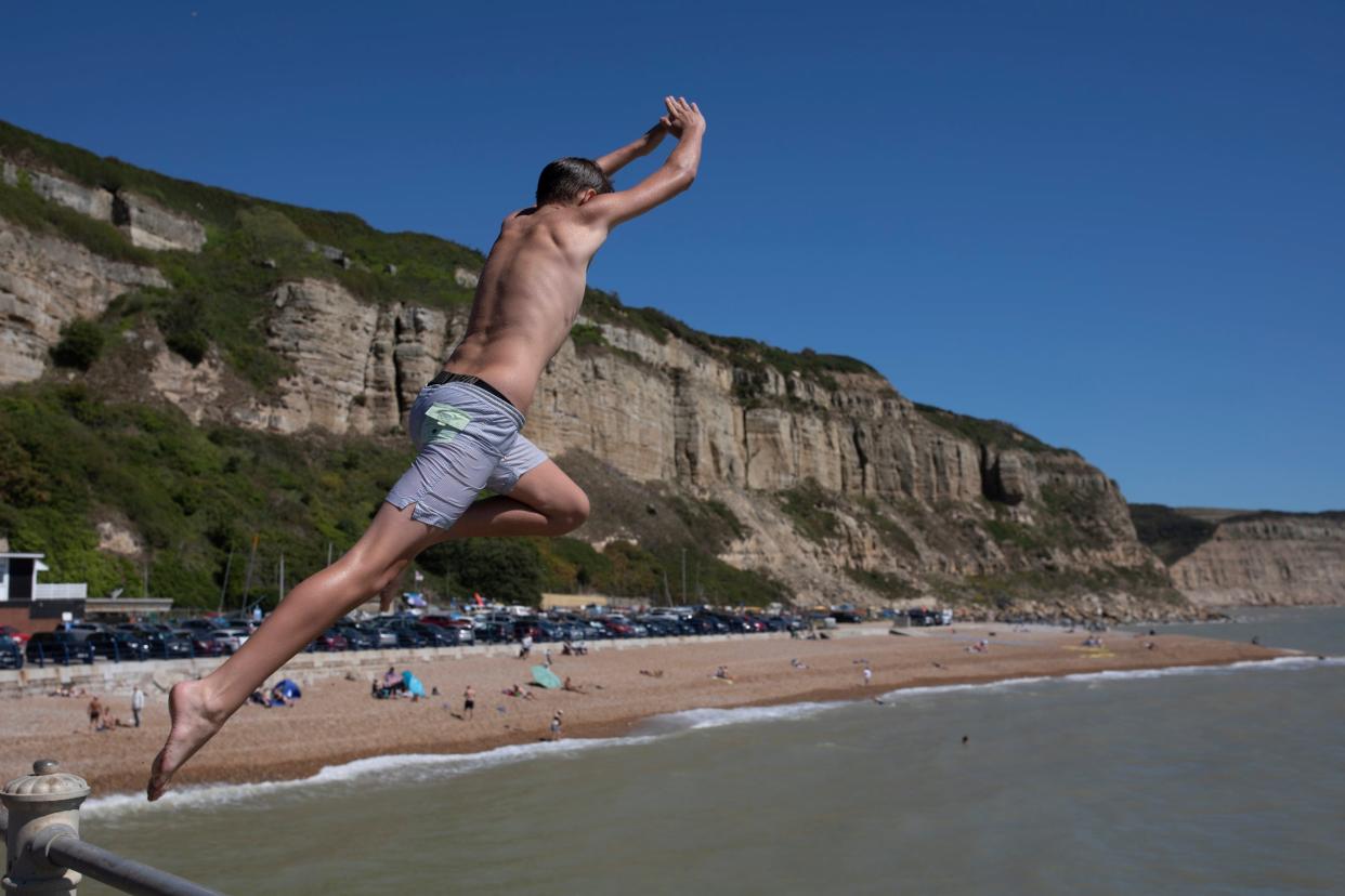 oungsters jump from a wall into the sea in Hastings: Getty Images