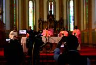 A camera crew record a live broadcast of the Catholic mass at the Rubaga Cathedral amid concerns about the spread of coronavirus disease (COVID-19) in Kampala