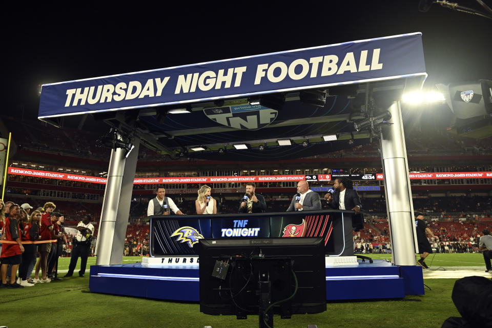 The Thursday Night Football crew, from left, Tony Gonzalez, Charissa Thompson, Ryan Fitzpatrick, Andrew Whitworth, and Richard Sherman, are shown before an NFL football game between the Baltimore Ravens and Tampa Bay Buccaneers Thursday, Oct. 27, 2022, in Tampa, Fla. (AP Photo/Jason Behnken)