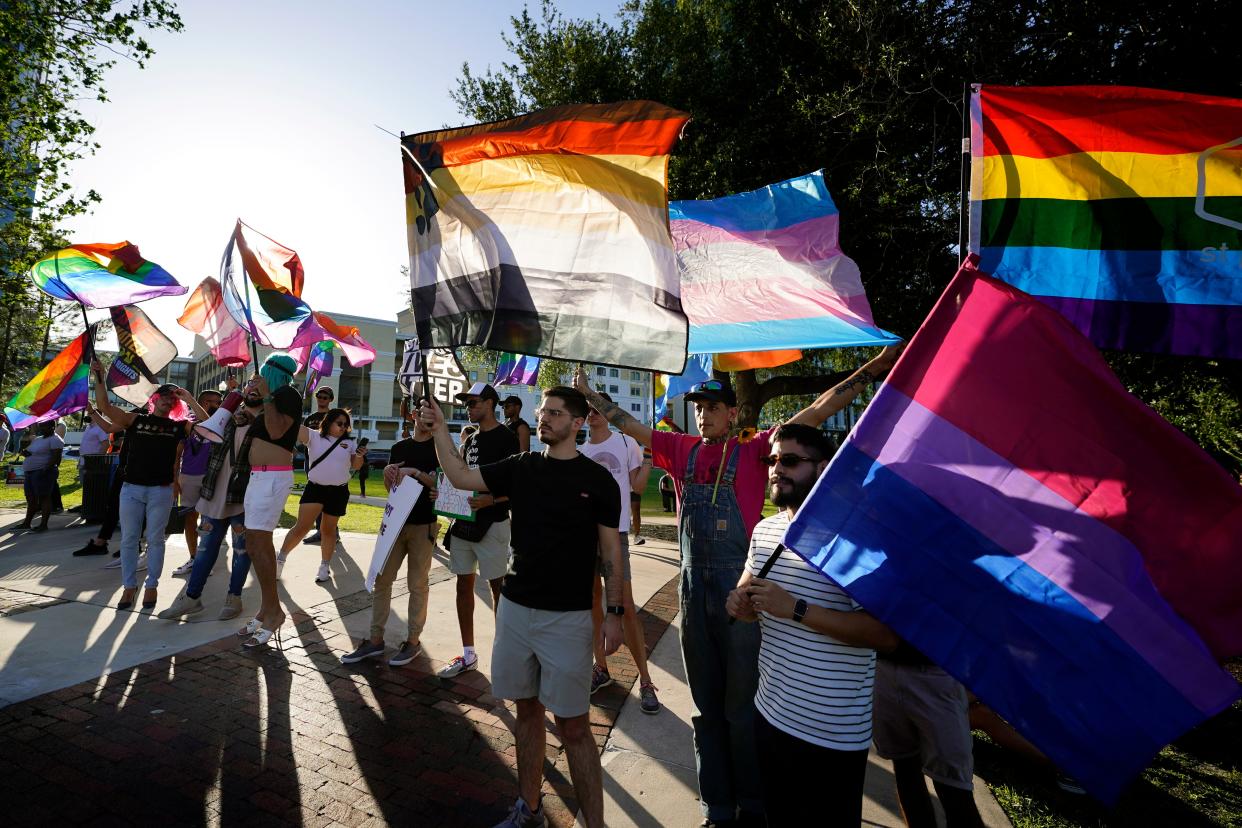 Protesters wave pride flags in a rally and march on May 1 in Orlando, Fla.