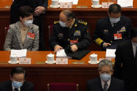 Hong Kong Chief Executive Carrie Lam, top left, talks with a fellow delegate before the opening session of China's National People's Congress (NPC) at the Great Hall of the People in Beijing, Friday, March 5, 2021. (AP Photo/Andy Wong)