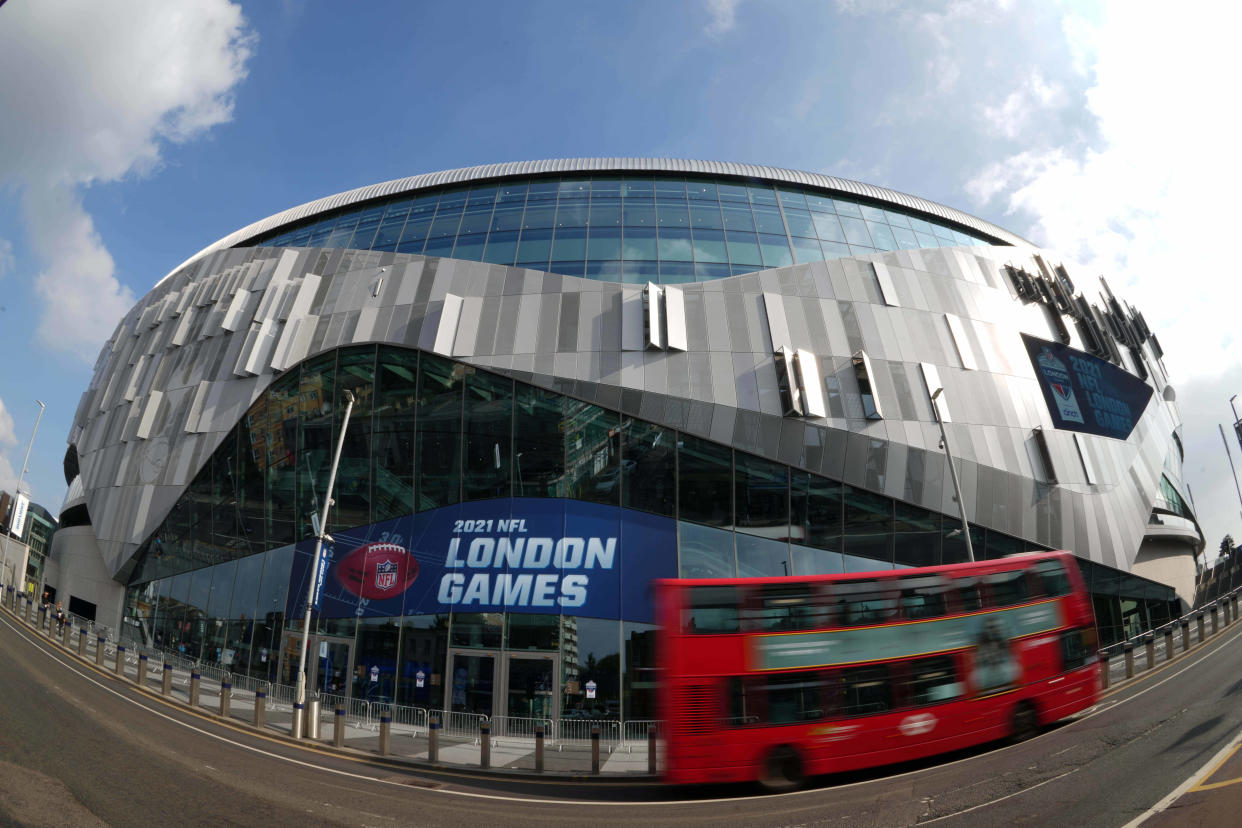 A red double decker buss passes by Tottenham Hotspur Stadium in 2021.