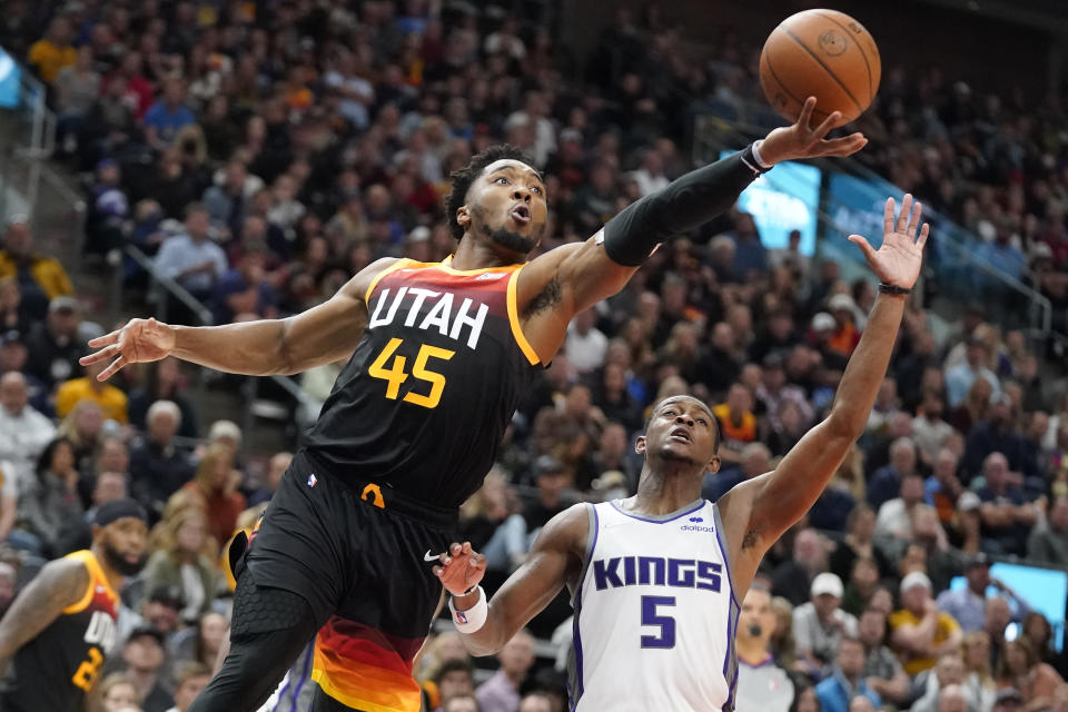 Utah Jazz guard Donovan Mitchell (45) goes to the basket as Sacramento Kings guard De'Aaron Fox (5) defends during the first half of an NBA basketball game Tuesday, Nov. 2, 2021, in Salt Lake City. (AP Photo/Rick Bowmer)