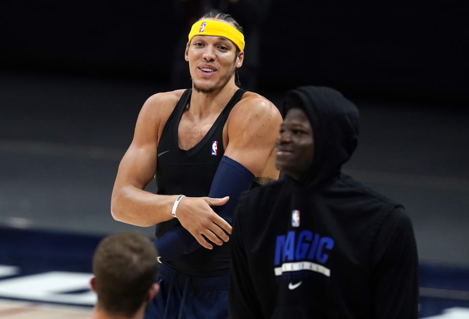 Denver Nuggets forward Aaron Gordon, back, jokes with former teammates as members of the Orlando Magic warm up before the first half of an NBA basketball game Sunday, April 4, 2021, in Denver. Gordon was acquired by the Nuggets before the NBA trading deadline. (AP Photo/David Zalubowski)