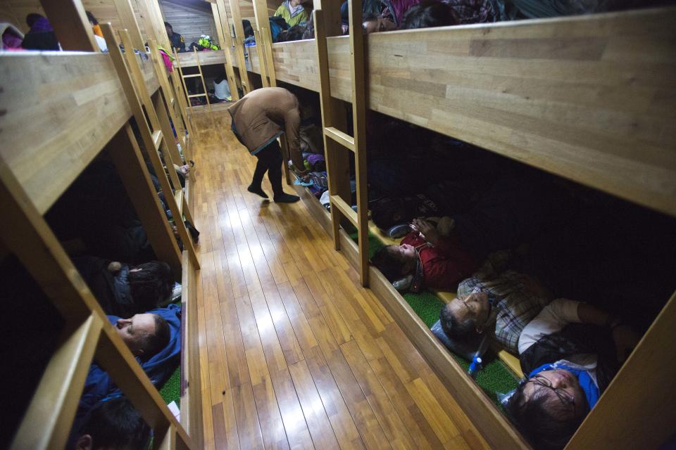 In this Saturday, Aug. 10, 2013 photo, hikers are packed into sleeping rows at a rest station before the summit of Mount Fuji in Japan. The Japanese cheered the recent recognition of Mount Fuji as a UNESCO World heritage site, though many worry that the status may worsen the damage to the environment from the tens of thousands who visit the peak each year. (AP Photo/David Guttenfelder)