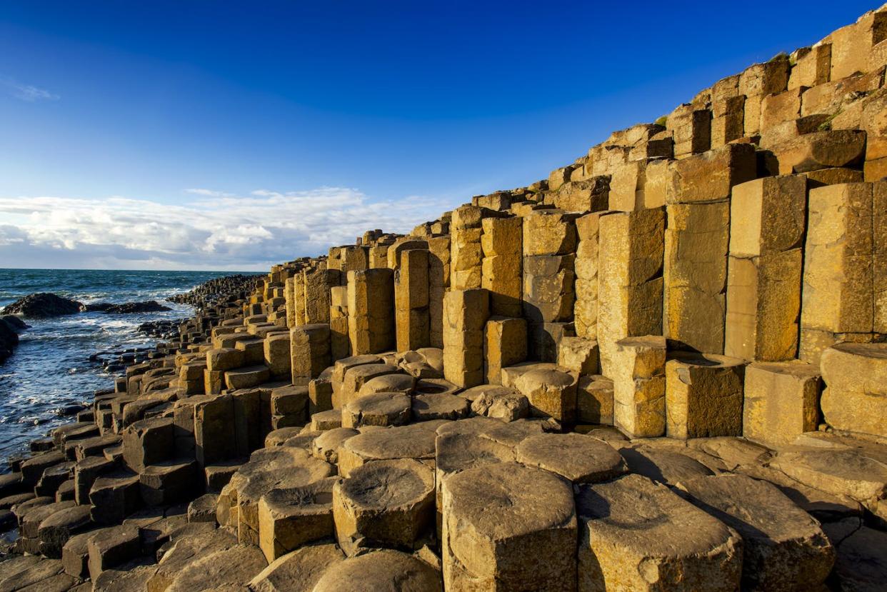 Giant's Causeway in Northern Ireland features around 40,000 exposed polygonal columns of basalt in perfect horizontal sections. <a href="https://www.gettyimages.com/detail/photo/the-unesco-world-heritage-site-giants-causeway-in-royalty-free-image/1311800218?adppopup=true" rel="nofollow noopener" target="_blank" data-ylk="slk:Chris Hill/Photodisc via Getty Images;elm:context_link;itc:0;sec:content-canvas" class="link ">Chris Hill/Photodisc via Getty Images</a>