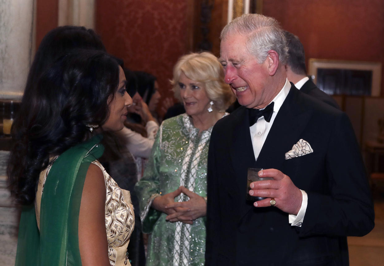 Charles and Camilla meet former cricketer Isa Guha as they host a reception for the British Asian Trust at Buckingham Palace [Photo: PA]