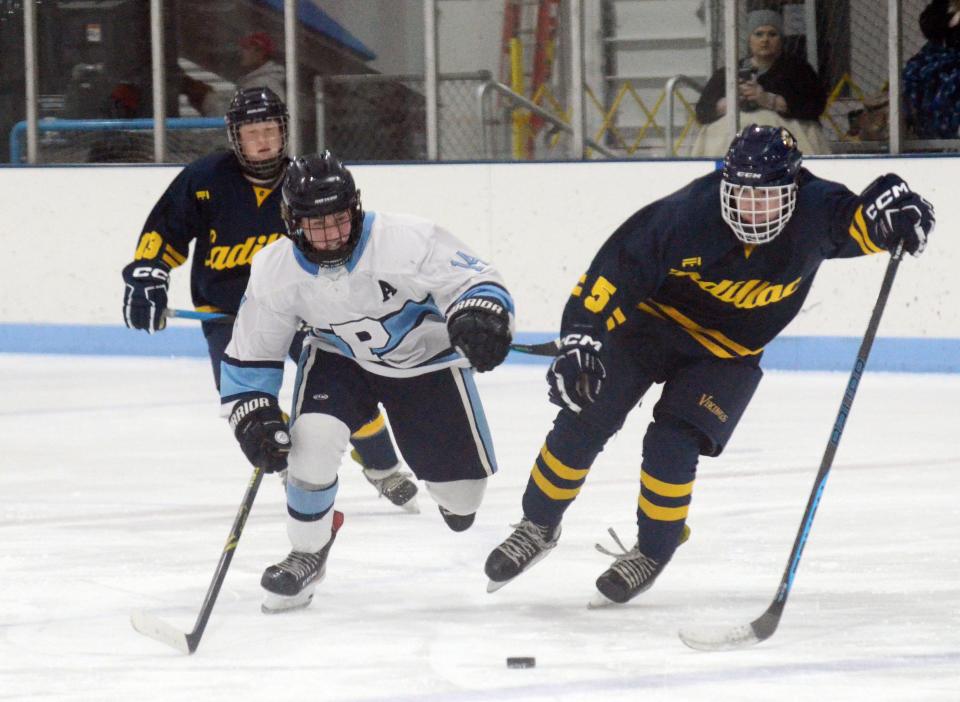 Petoskey's Noah Bodurka (left) races a Cadillac player to the puck during the third period of Wednesday's game at the Petoskey Ice Arena.