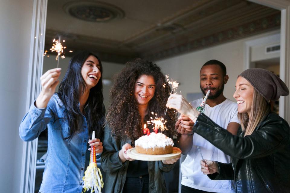 friends celebrating birthday with cake